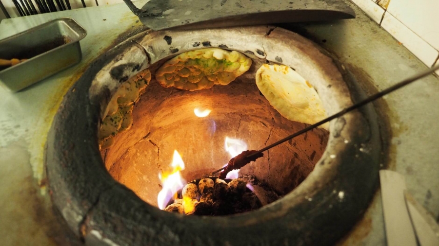  ti
Traditional old fashioned Tandoor used in Northern India (Image shows - Naan, which is traditional Indian bread, being prepared along with chicken).