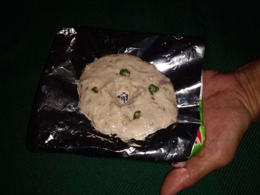 Making raw Vada, with hole in center, over a silver foil as described in Medu Vada Recipe.