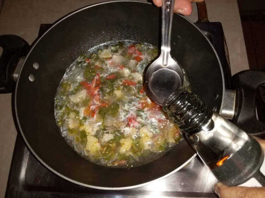 Vinegar being added to the prepration in Recipe for Vegetable Soup.