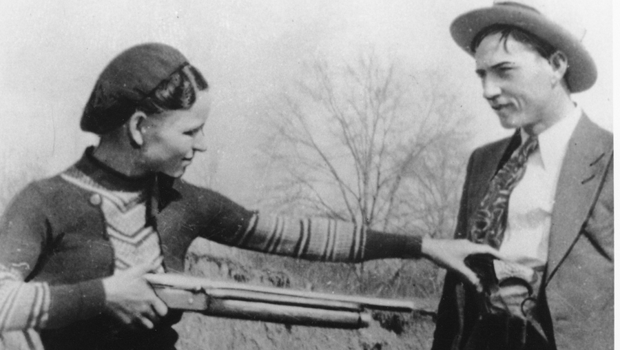 Bonnie playfully points a shotgun at Clyde