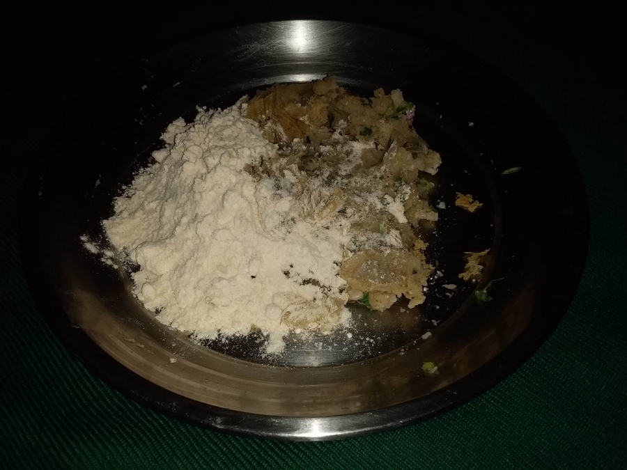 Mixing white flour with Aloo mixture in Recipe for Aloo Paratha.