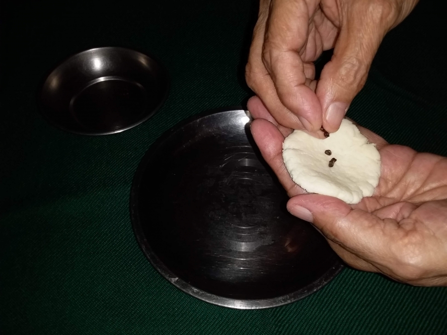 Putting elaichi into the dough piece in Recipe of Gulab Jamun with Khoya.