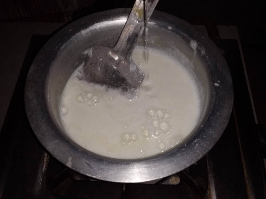 Lemon juice being added to milk for curdling in Rasgulla Recipe.