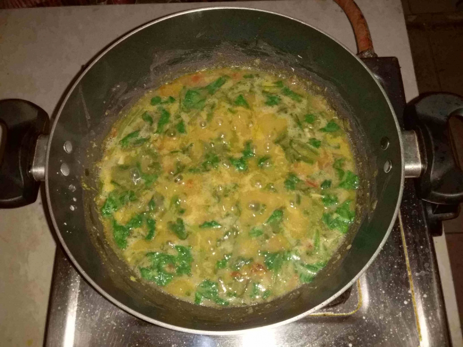 Spinach being cooked with the Dal mixture in preparation of Recipe for Dal Palak.