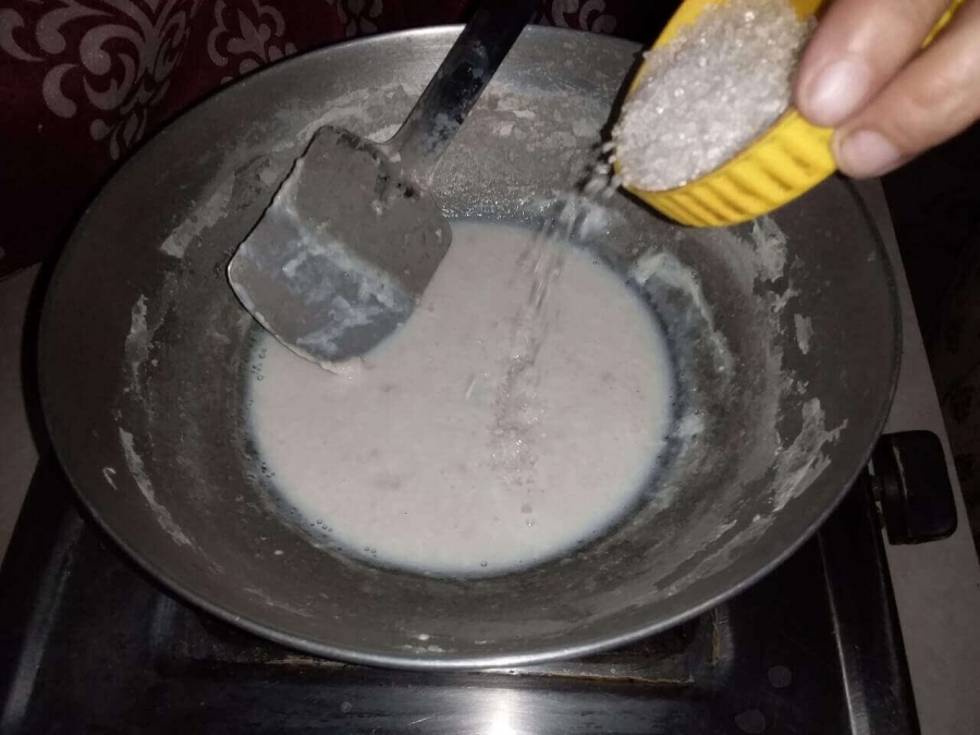 Sugar being mixed to concentrated milk in Recipe for Rabri.