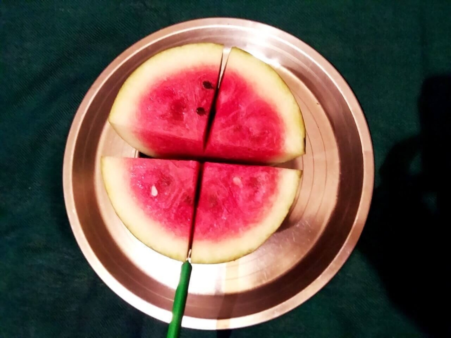 Watermelon being cut longitudinally once again as described in Recipe of Watermelon Juice preparation.