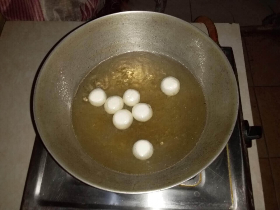 Rasgulla dropped in boiling sugar syrup as described in Recipe of making Rasgulla.