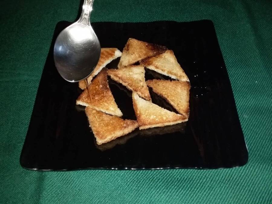 Sugar syrup being spread on the fried bread pieces as described in Recipe of Shahi Tukda.