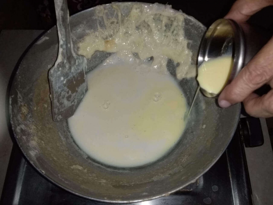 Saffron milk being added to the concentrated milk in Rabri Recipe.