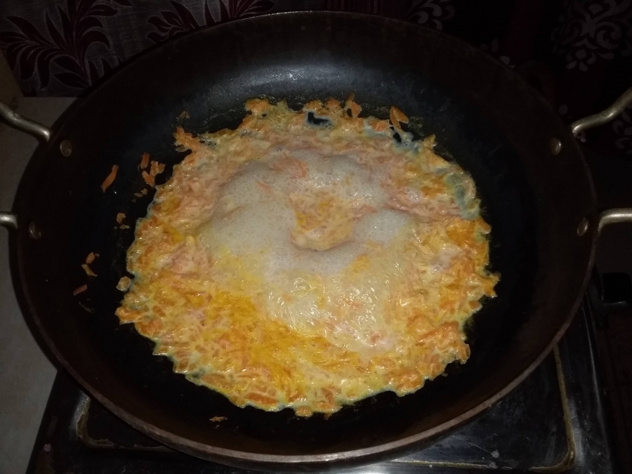 Boiling carrot and milk mixture during Gajar Ka Halwa preparation.