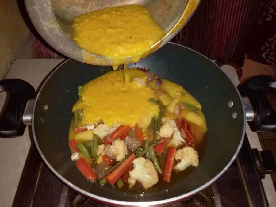 Dal being added to the boiled vegetables as described in Recipe of Sambar for Idli.